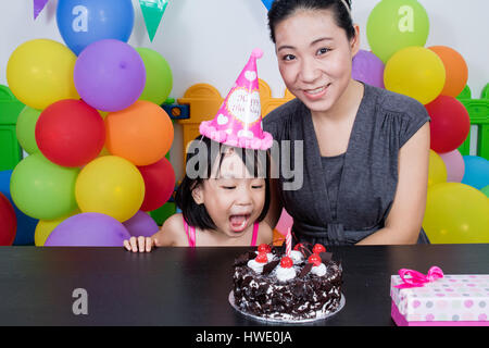 Petite fille asiatique chinois et mère célébrer Anniversaire en jeu intérieur Banque D'Images