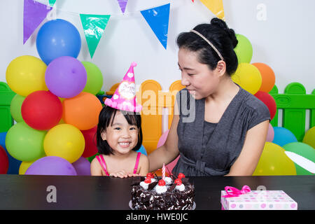 Petite fille asiatique chinois et mère célébrer Anniversaire en jeu intérieur Banque D'Images