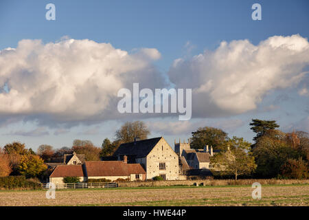 Vue sur les terres agricoles vers le village de Somerford Keynes dans la Loire avec conversion des granges et une tour de l'église Banque D'Images