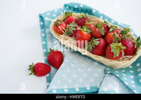 Fraises fraîches dans le bac en osier sur fond blanc Banque D'Images