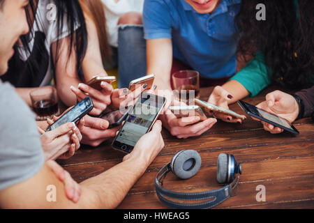 Vue d'en haut les mains à l'aide de cercle à cafe - téléphone mobile amis multiraciale dépendant du haut - scène d'intérieur Wifi connecté les gens en réunion de la table de bar Banque D'Images