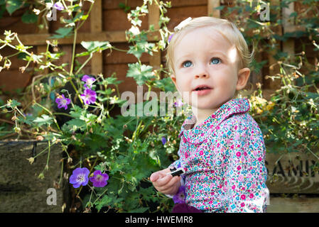 Blue Eyed baby girl in garden Banque D'Images