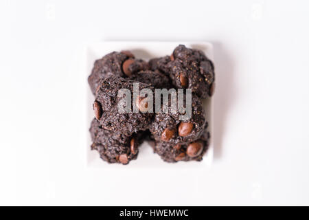Pile de chocolats végétaliens sur plaque carrée blanc Banque D'Images