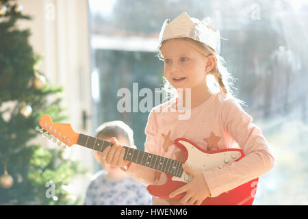 Girl Playing with toy guitar le jour de Noël Banque D'Images