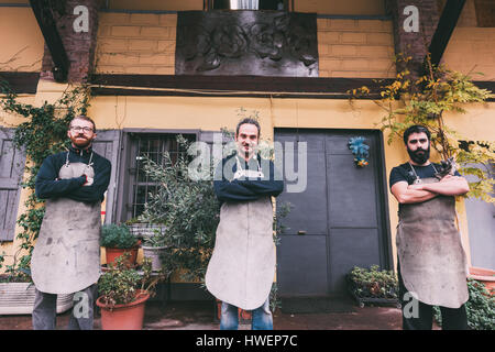 Portrait de trois hommes de la métallurgie avec bras croisés en dehors de forge Banque D'Images