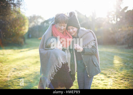 Grand-mère et petites-filles hugging in garden Banque D'Images