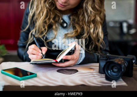 Woman at cafe écrit dans l'ordinateur portable Banque D'Images