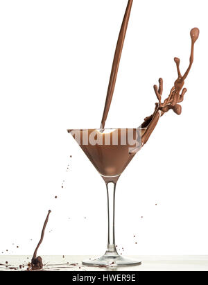 L'analyse macro avec le chocolat chaud de tomber dans le verre on white en studio Banque D'Images