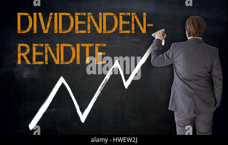 Businessman écrit dividendenrendite (en allemand) Dividendes sur tableau noir concept. Banque D'Images