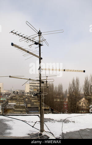 Vieux téléviseur-antenne sur le toit d'un bâtiment entouré d'un blanc neige Banque D'Images