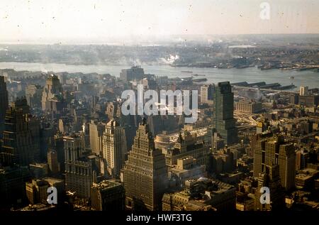 Vue panoramique vers le sud-ouest du quartier de Times Square, Hells Kitchen, Chelsea, et le côté ouest de Manhattan, à New York City, New York, 1957. Dans l'arrière-plan est la rivière Hudson, et au-delà est la ville de Hoboken, New Jersey. À la partie inférieure gauche, plusieurs bâtiments à Times Square sont visibles : Une fois Square, les Forces armées de recrutement avec l'avion sur le haut, l'une des capacités au 1501 Broadway, et l'ancien Hôtel Astor immédiatement à droite entre les 44e et 45e. Directement derrière l'ancienne New York Times Building au 229 43e Rue Ouest. L'Autorité portuaire de New York Banque D'Images