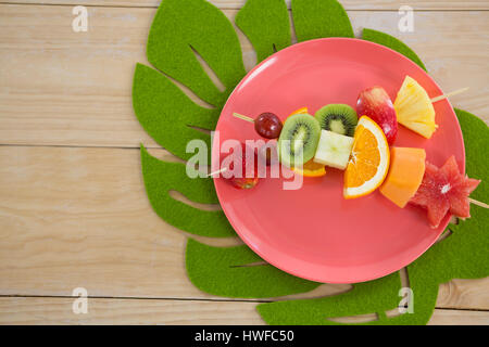 Frais généraux de brochettes de fruits dans la plaque sur la table en bois Banque D'Images