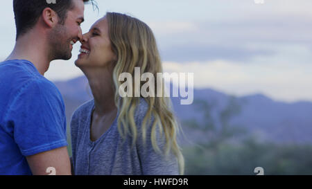 Low angle view of smiling couple touching noses dans paysage à distance Banque D'Images