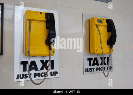 Taxi jaune téléphone dédié dans les lignes d'entraînement du centre de transport de l'Irlande du Nord Belfast Banque D'Images