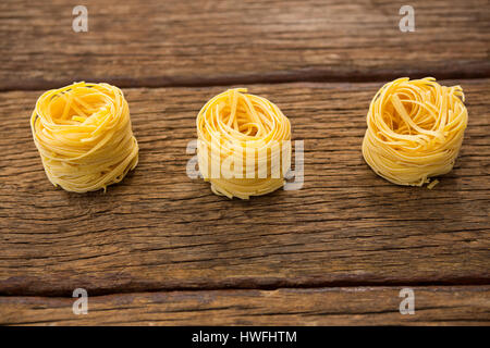 Tagliatelles disposés en une rangée sur la surface en bois Banque D'Images
