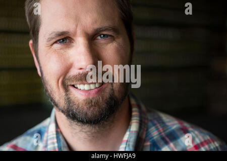Close up portrait of smiling male worker in warehouse Banque D'Images