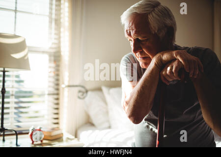 Happy man avec sa canne dans la chambre à coucher à la maison Banque D'Images