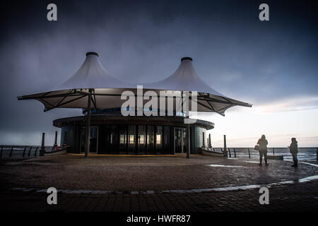 Aberystwyth, Pays de Galles, Royaume-Uni. 20 mars, 2017. Météo France : Heavy Rain sombres nuages de tempête de recueillir de façon spectaculaire au crépuscule sur le kiosque distinctif à Aberystwyth sur la baie de Cardigan, l'ouest du pays de Galles à la fin de l'équinoxe du printemps 24. Froid et l'hiver est prévu pour les prochaines 24 heures, avec la pluie et la neige attendue dans certaines régions du nord ouest de l'équinoxe du printemps est important parce qu'après un long et sombre hiver, les heures du jour et de la nuit sont à peu près égales pour la première fois cette année - environ 12 heures. Photo © Keith Morr Banque D'Images
