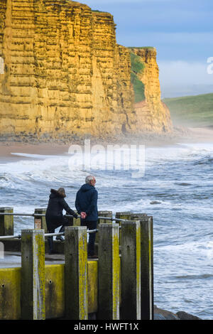 West Bay, Dorset, UK. Le 20 mars 2017. Météo britannique. Un couple en admirant la vue à partir de la jetée est de West Bay, dans le Dorset comme le soleil commence à percer les nuages après un temps couvert et humide matin. Crédit photo : Graham Hunt/Alamy Live News Banque D'Images