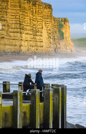 West Bay, Dorset, UK. Le 20 mars 2017. Météo britannique. Un couple en admirant la vue à partir de la jetée est de West Bay, dans le Dorset comme le soleil commence à percer les nuages après un temps couvert et humide matin. Crédit photo : Graham Hunt/Alamy Live News Banque D'Images