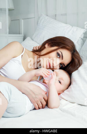 Heureux belle mère avec son fils âgé d'un an au lit à la maison Banque D'Images