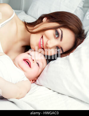 Heureux belle mère avec son fils âgé d'un an au lit à la maison Banque D'Images