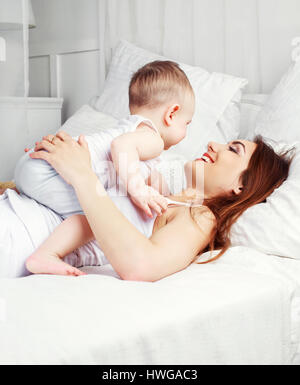 Heureux belle mère avec son fils âgé d'un an au lit à la maison Banque D'Images