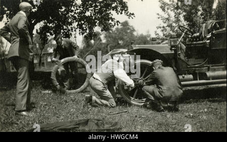 Meubles anciens c1905 photo, un groupe d'hommes changer un pneu à plat sur une antique runabout voiture. Emplacement inconnu, probablement à New York. Voir Alamy Images HWGCMD HWGCKW HWGCKR, et d'autres vues de cette voiture. SOURCE : tirage photographique original. Banque D'Images