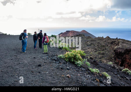 Cumbre Vieja, Fuencaliente. La Palma. Une vue le long de la crête sinueuse du volcan et la formation géologique la terre. Très peu de végétation à l'exception d'Echium Brevirame croissant dans la roche de lave de Cumbre Vieja région. C'est un jour lumineux avec des nuages en mouvement rapide. Les randonneurs à pied le long de la crête sur le sentier sentier. Banque D'Images