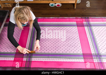 L'impression de bloc, femme d'appuyer sur le bloc de bois avec de la peinture sur tissu, Bad Aussee, Styrie, Autriche Banque D'Images