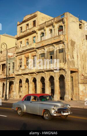 Cuba, La Havane, Malecon, vieille voiture américaine en passant en face d'un bâtiment néoclassique Banque D'Images