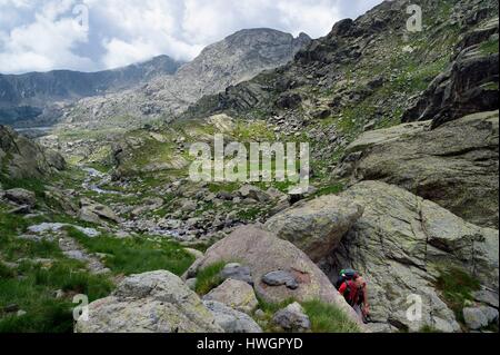 France, Alpes Maritimes, le parc national du Mercantour (Parc National du Mercantour), randonneur sur le sentier GR 52, la Vallée des Merveilles (Vallée des Merveilles) parsemée de milliers de gravures rupestres de l'âge du bronze et la paroi vitrifiée à l'arrière-plan Banque D'Images