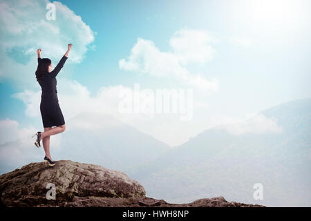 Asian business woman standing sur le sommet de la montagne. La réussite de l'entreprise concept Banque D'Images