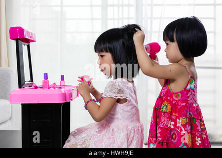 Chinois asiatique Petites Sœurs jouant avec Make-Up Toys à la maison. Banque D'Images