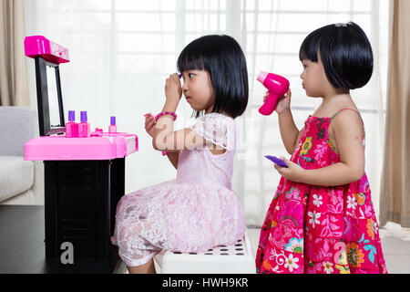 Chinois asiatique Petites Sœurs jouant avec Make-Up Toys à la maison. Banque D'Images