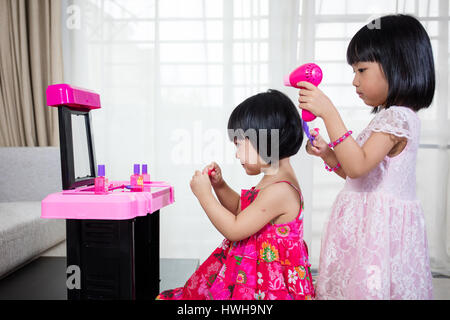 Chinois asiatique Petites Sœurs jouant avec Make-Up Toys à la maison. Banque D'Images