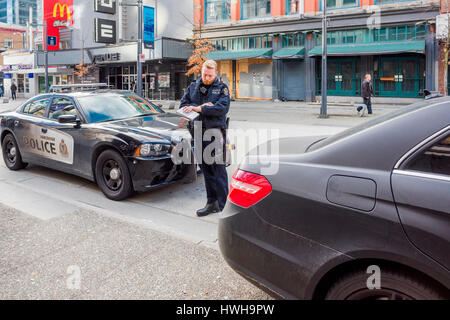 Officier de police dans le proces de l'émission d'une contravention de la circulation, Vancouver, Colombie-Britannique, Canada. Banque D'Images