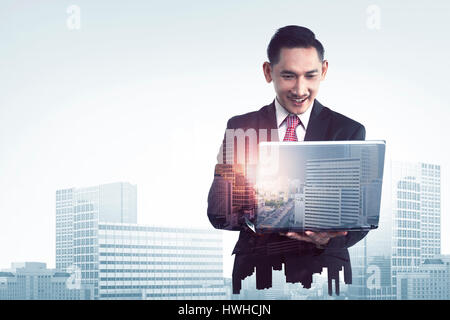 Double exposition d'affaires asiatiques man with laptop combinée avec des capacités Banque D'Images
