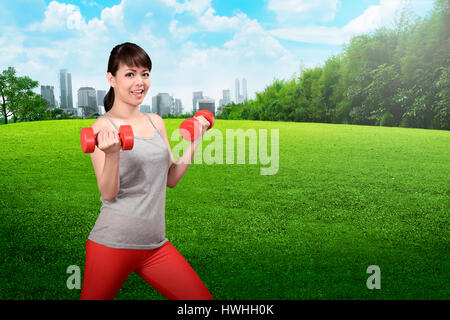 Asian woman doing exercise sur le parc de la ville Banque D'Images