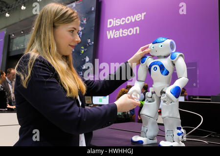 Hanovre, Allemagne, le 20 mars 2017 - Technologies numériques salon CeBIT. Une hôtesse stand touche un robot humanoïde NAO Watson au stand IBM Banque D'Images