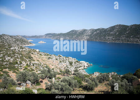 Avis de Kalekoy Simena bay dans Uchagiz village d'Antalya province de Turquie avec tombeaux lyciens à gauche et certains bateaux touristiques Banque D'Images