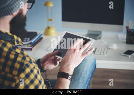 Vue arrière de l'homme travaillant avec digital tablet Banque D'Images