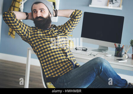 L'homme d'affaires de vous coucher sur un chaise à côté d'ordinateur Banque D'Images