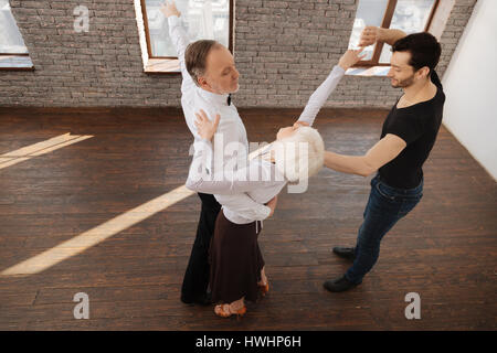 L'enseignement de la grâce. Attention charmante qualifiés âgés de l'enseignement de la table de danse tango retraités tout en ayant soin d'exprimer et session de formation Banque D'Images