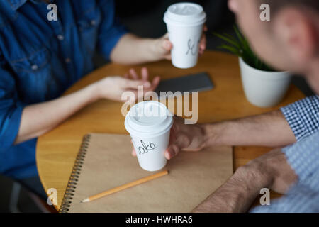 Close-up shot of young HR manager assis à table de café, boire un café délicieux et la conduite d'entretien avec candidate pour le poste Banque D'Images