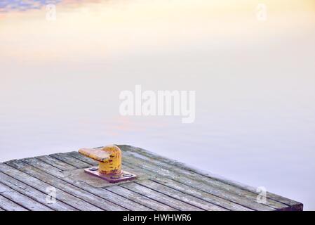 Borne lumineuse jaune, ou un port post, sur une jetée en bois. Vu la rouille sur la surface. Banque D'Images