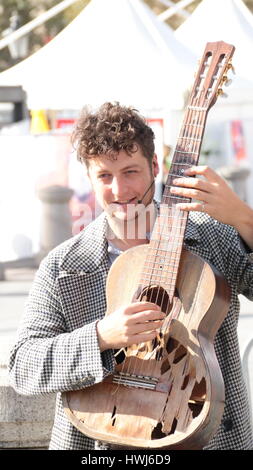 Busker mâle qui joue de la guitare et chant Banque D'Images