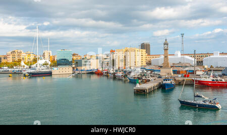 L'homme apporte son voilier en très lente Marina Port Vell à Barcelone, Espagne. Bateaux amarrés dans le port, amarré à côté de la ville. Port moderne Banque D'Images