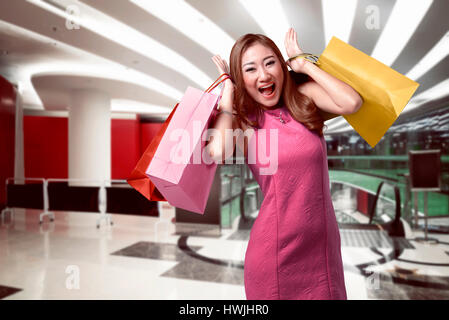 Portrait of asian woman holding dans ses mains beaucoup de panier à l'intérieur fond mall Banque D'Images