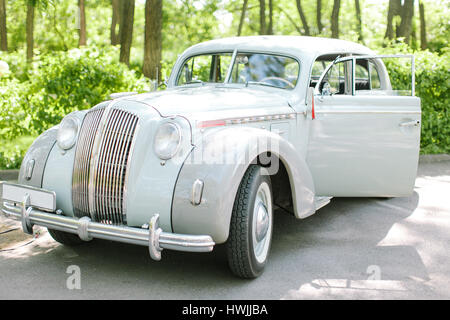 Voiture rétro gris sur fond vert nature. Banque D'Images